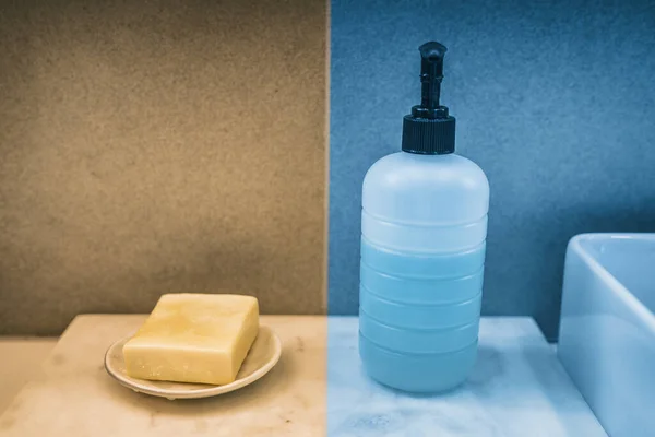Sabun çubuğuna karşı sıvı sabun şişesi ev banyosundaki el yıkama ürünleri karşılaştırması. Karşılaştırmak için sarı ve mavi renkli kutular — Stok fotoğraf
