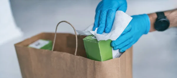 Coronavirus essuyant les paquets d'épicerie après avoir reçu la livraison à domicile portant des gants, en utilisant des lingettes désinfectantes pour nettoyer les surfaces. Nettoyage du virus COVID-19 — Photo