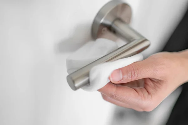 Coronavirus COVID-19 Prevention cleaning woman wiping doorknob with antibacterial disinfecting wipe for killing corona virus on touching surfaces or touching public bathroom handle with tissue — Stock Photo, Image