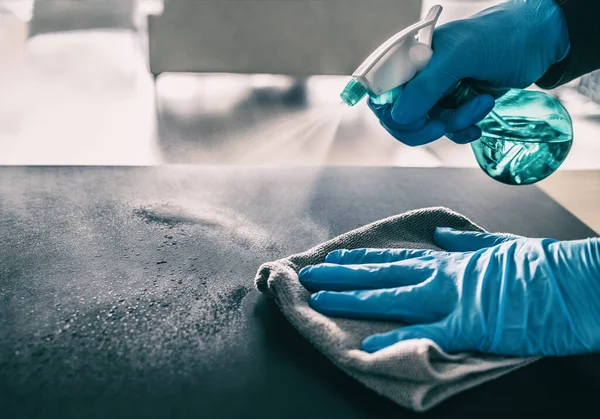Yüzey COVID-19 salgınına karşı sterilize ediliyor. Evde temizlik spreyi sıkan antibakteriyel sprey şişesi Coronavirus 'a karşı nitril eldiven takan. Hastane yüzeylerini sterilize edin. — Stok fotoğraf