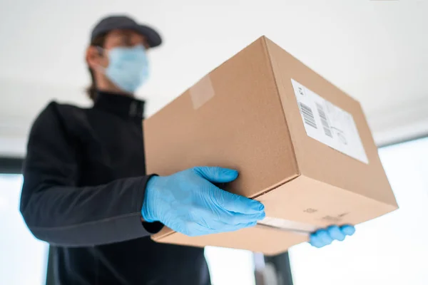 Home delivery shopping box man wearing gloves and protective mask delivering packages at door — Stock Photo, Image