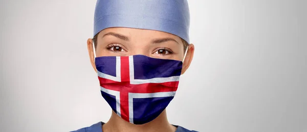 Исландский флаг Исландия COVID-19 панорамный баннер Corona virus outbreak pandemic doctor woman wearing PPE protective face mask for coronavirus prevention. Азиатская медсестра счастлива. Медицинский работник помогает — стоковое фото