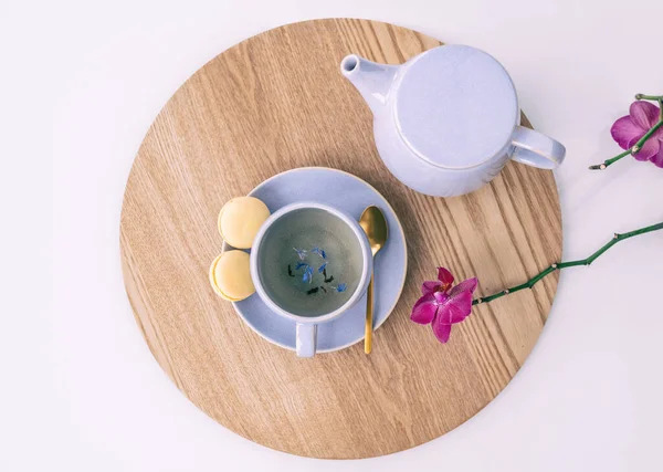 Çay fincanı Earl Grey İngiliz çayı, çaydanlık ve tatlı limonlu badem kurabiyesi evde yemek servisi yapan masa üstü. Mor leylak yaprakları ve orkideleriyle — Stok fotoğraf