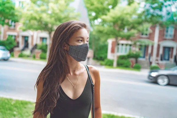 Aziatische vrouw lopen in de stad straat dragen gezichtsmasker voor COVID 19 preventie. Gelukkige jonge student met mode patroon doek mond bekleding buiten. Corona-virusconcept — Stockfoto