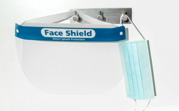 PPE supplies face shield direct splash protection and mask hanging on hooks. New clean corona virus protective equipment ready to use for coronavirus prevention — Stock Photo, Image