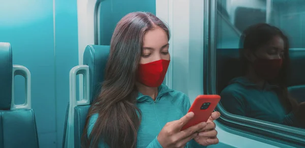 Masque facial dans les transports en commun comme le train, le bus. Passager femme utilisant un téléphone portable avec couverture de visage pendant le trajet en métro la nuit — Photo