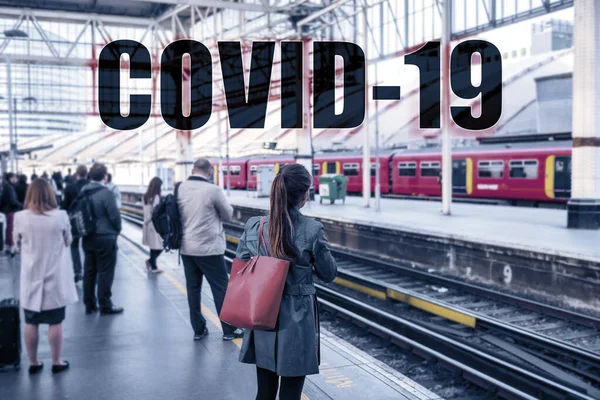 COVID-19 Text sign over travellers commuting at train station. Travel ban quarantine for public transport over Corona virus fear. Coronavirus panic social distancing people — Stock Photo, Image