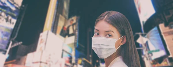Corona vírus NYC utazási tilalom Kína nő turista sétál a New York-i utcában védőmaszkot visel a koronavírus világjárvány. Panoráma banner háttér éjszakai városkép — Stock Fotó