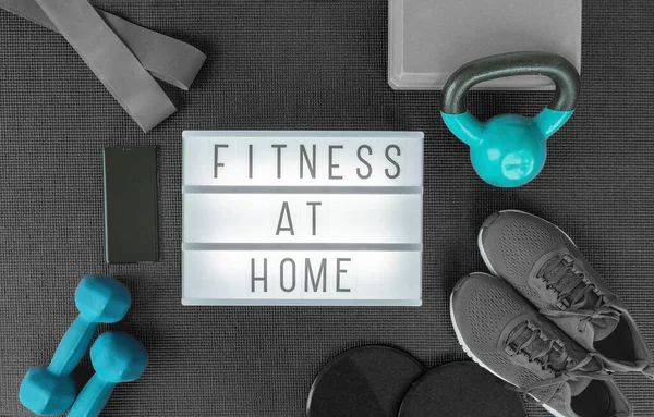Spor salonunda ağırlık kaldırma, egzersiz minderinde çapraz egzersiz için direnç bantları. Siyah gri ekipmanlı ışık kutusu tabelasının üst görüntüsü. — Stok fotoğraf