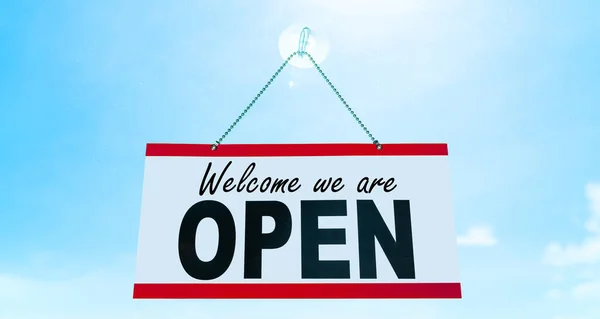 COVID-19 Open business teken zeggen Welkom zijn we OPEN opknoping op etalage etalage heropening Retail bedrijven weer openen. Zon blauwe lucht zomer achtergrond. einde van de opsluiting — Stockfoto