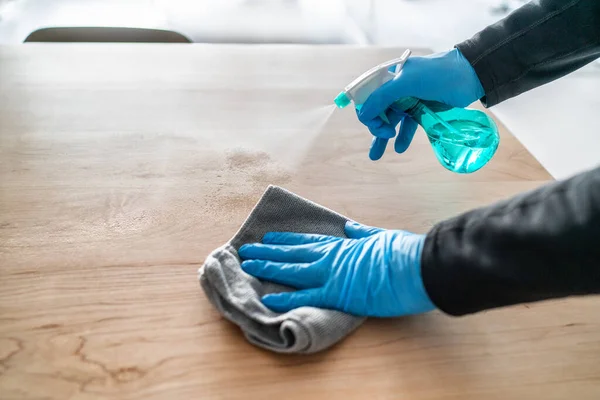 Surface cleaning spraying antibacterial sanitizing liquid with bottle washing table top at home . Man using gloves and towel doing spring cleaning — Stock Photo, Image