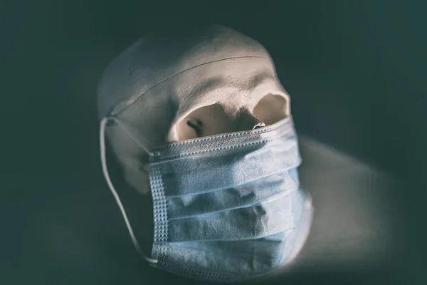 COVID-19顔の医療用マスクを着用した頭蓋骨。コロナウイルス死の概念 — ストック写真