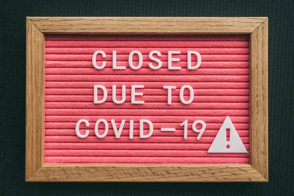 Coronavirus lagra stängningsskylt. Stängt på grund av COVID-19 anslagstavla för detaljhandel COVID-19 pandemiutbrott. Stängning av restauranger, bagerier, icke väsentliga tjänster. Rosa bokstäver — Stockfoto