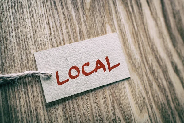 Etiqueta de caja de regalo de papel escrita a mano LOCAL sobre fondo de textura de madera marrón, para comprar economía local pequeña — Foto de Stock