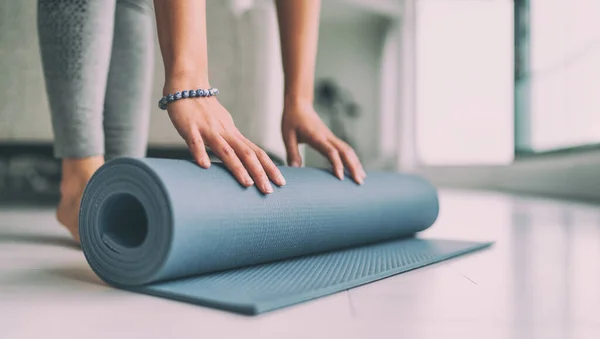 Joga w domu aktywny styl życia kobieta walcowanie maty do ćwiczeń w salonie na rano medytacja joga baner tło — Zdjęcie stockowe