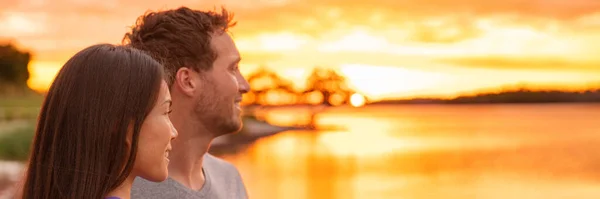 Interracial jovem casal assistindo pôr do sol juntos bandeira panorama. Mulher asiática, homem caucasiano perfil retrato com fundo brilhante — Fotografia de Stock