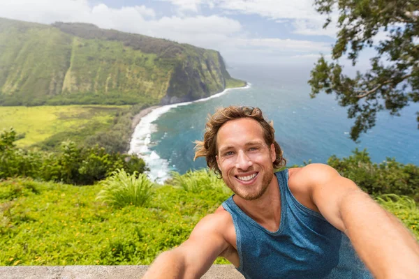 Selfie turista turista fotit self-portrét na Waipio Valley vyhlídka na Big Island, Havaj. Muž batohem s úsměvem na kameře telefon na dobrodružství cestování přírodou — Stock fotografie