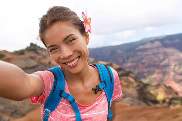 Selfie excursionista turista de viajes en Waimea Canyon Hawaii senderismo tomando foto autorretrato con el teléfono de la cámara que se divierten haciendo senderismo en las montañas de Kauai, Hawai. Mujer tomando fotos en viajes de aventura —  Fotos de Stock