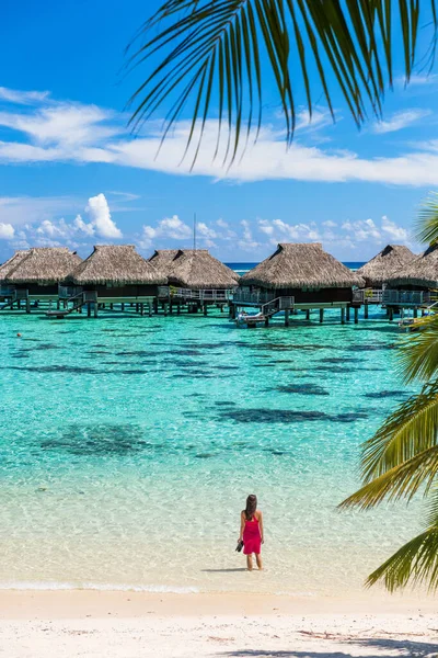 Lujosa mujer de vacaciones en Tahití. Turista disfrutando del agua del mar en villas bungalow hotel sobre el agua en Polinesia Francesa, Isla Moorea en el sur del Pacífico, famoso destino de escapada — Foto de Stock