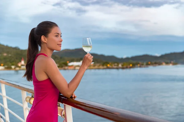 Luxuoso cruzeiro navio férias elegante mulher beber copo de champanhe no jantar desfrutando de vista para o mar de barco. ásia senhora no vermelho vestido relaxante no deck ao ar livre — Fotografia de Stock