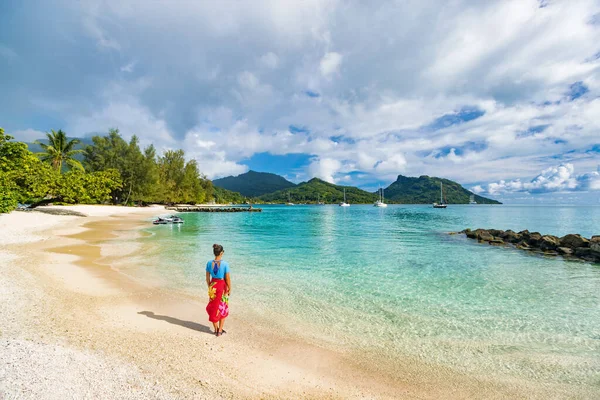 Huahine Adası 'ndaki Fransız Polinezya plajındaki gezgin kadın. Tatil gezisi Tahiti Tatil Gezisi. Polinezya giysili mayo giyen kumda rahatça yürüyen bir kız. — Stok fotoğraf