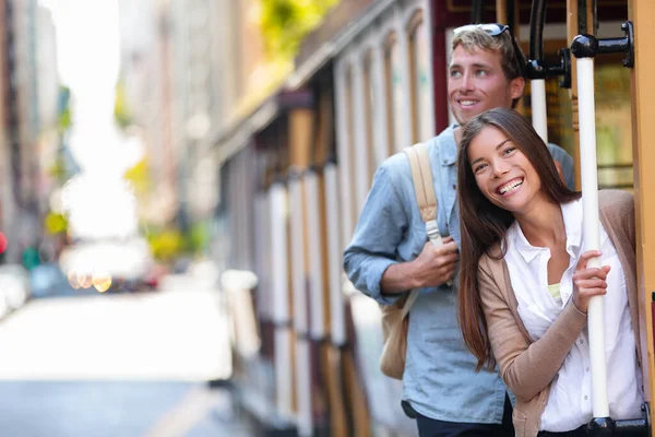 San Francisco touristes de la ville à cheval téléphérique tourisme gens style de vie. Jeune couple interracial appréciant le trajet du système de téléphérique, attraction de voyage populaire. — Photo