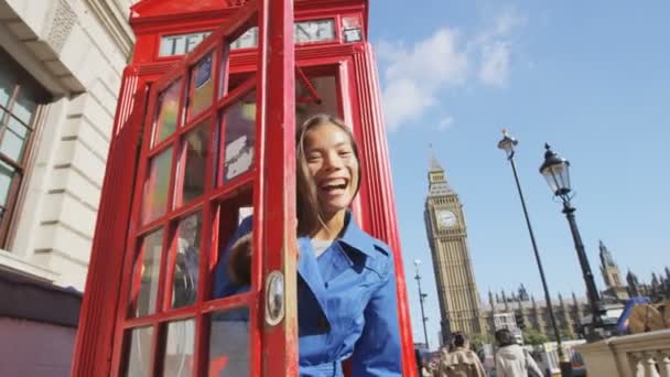 Glad kvinna vinka på röd telefon i London England — Stockvideo