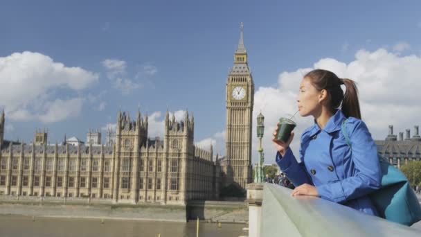 Молода дівчина, що п "є зеленого глазурі на Вестмінстерському мості (Лондон). — стокове відео