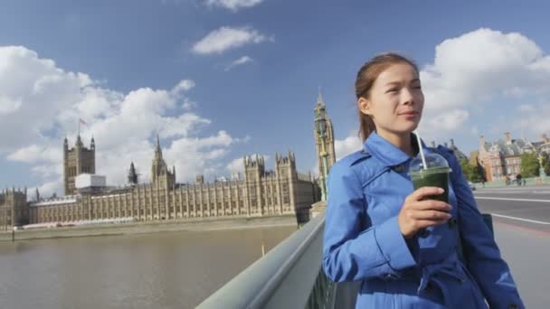 Donna che beve frullato vegetale verde sul ponte di Westminster Londra — Video Stock