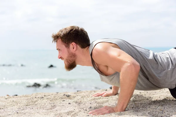 Fitness uomo che fa esercizio push-up sulla spiaggia — Foto Stock