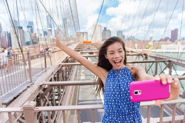 Feliz selfie turista mujer tomando divertido teléfono foto en Brooklyn Brige, Nueva York —  Fotos de Stock