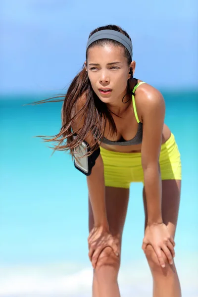 Втомлена жінка біжить після тренування дихання робить перерву від бігу на пляжі — стокове фото