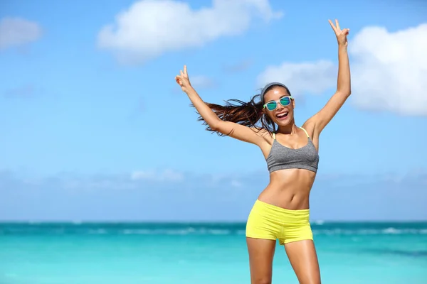 Šťastný veselý fitness žena v slunečních brýlích vítězné paže nahoru dělat v rukou značky — Stock fotografie