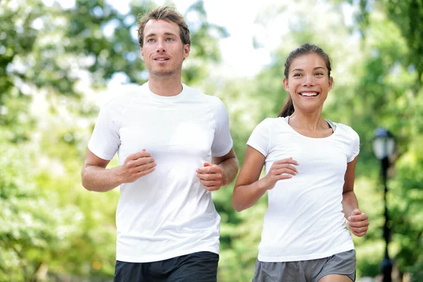Glada par löpare utbildning i sommar stadspark — Stockfoto
