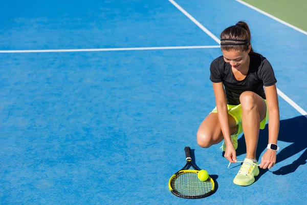 Tenista mujer atando cordones de zapatos en la cancha — Foto de Stock