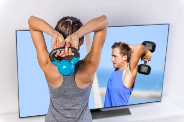 Fitness thuis - vrouw die TV-workout video volgt — Stockfoto