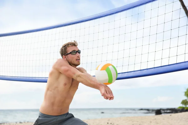 Пляжний волейболіст грає в гру, б'ючи м'яч — стокове фото