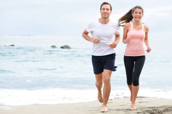 Laufendes Paar joggt am Strand — Stockfoto