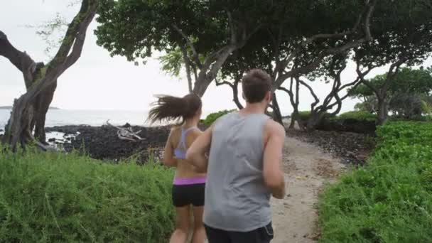 Pessoas correndo no caminho da trilha florestal pela praia — Vídeo de Stock