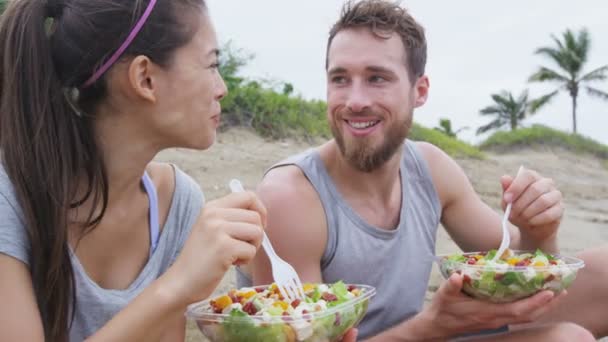 Jóvenes felices comiendo ensalada saludable para el almuerzo — Vídeos de Stock