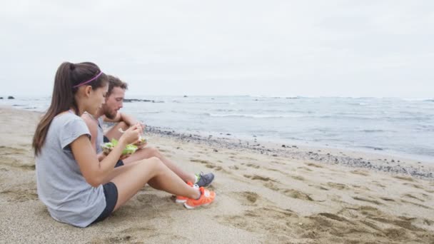 Jóvenes felices comiendo ensalada saludable para el almuerzo — Vídeos de Stock