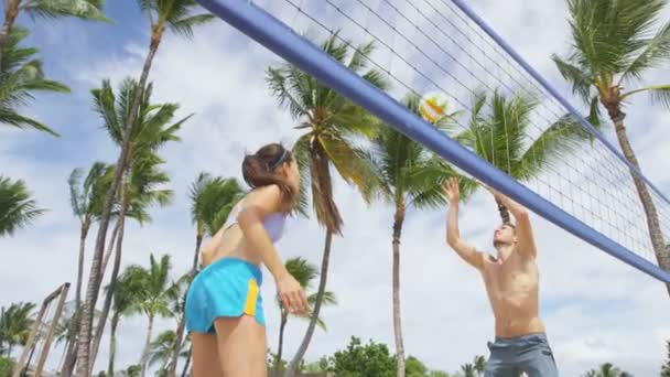 Друзья, играющие в пляжный волейбол — стоковое видео