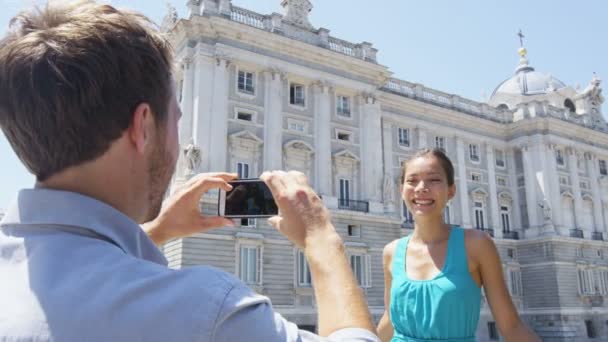 Pareja de turistas tomando fotos en el teléfono inteligente en Madrid — Vídeo de stock