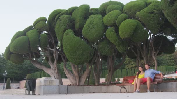 Coppia seduta alla panchina nel parco cittadino el Retiro a Madrid, Spagna. — Video Stock