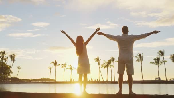 Sereno casal feliz desfrutando natureza pôr do sol levantando braços para o céu desfrutando de liberdade — Vídeo de Stock