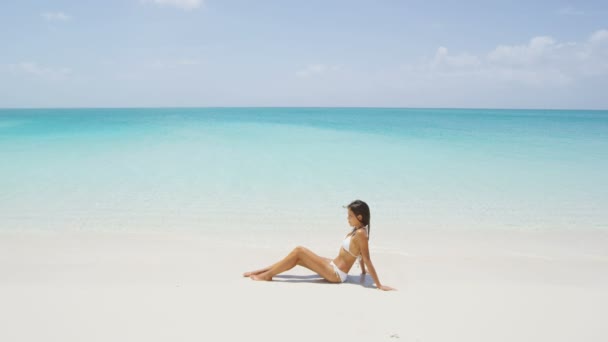 Beach vacation in summer - bikini girl sunbathing on travel holidays in paradise — Stock Video