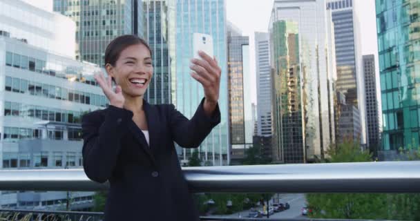 Empresária sorridente fazendo videochamada no celular contra prédios da cidade — Vídeo de Stock