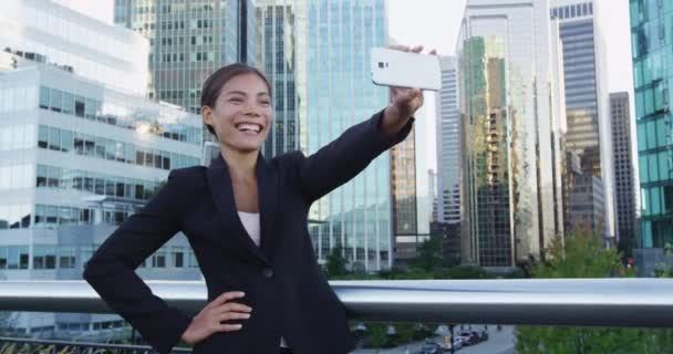 Smiling Businesswoman Taking Selfie With Mobile Phone Against Office Buildings — Stock Video