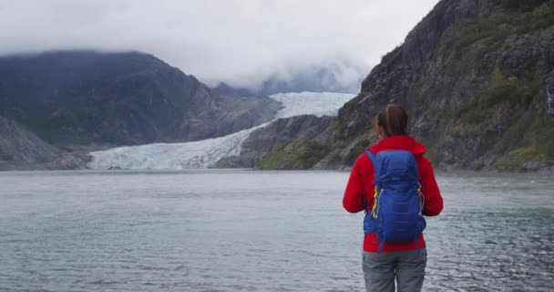 Femme de randonnée portant un sac à dos de randonneur en Alaska regardant le paysage des glaciers — Video