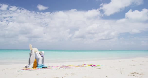 Παραλία σκηνή με τσάντα θαλάσσης γεμάτη αξεσουάρ ξαπλωμένη στην πετσέτα θαλάσσης — Αρχείο Βίντεο